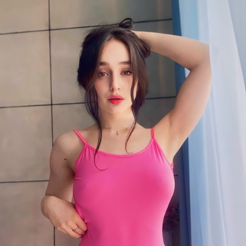 Woman in a pink outfit posing indoors, promoting OnlyFans Thai content with a soft and elegant look.